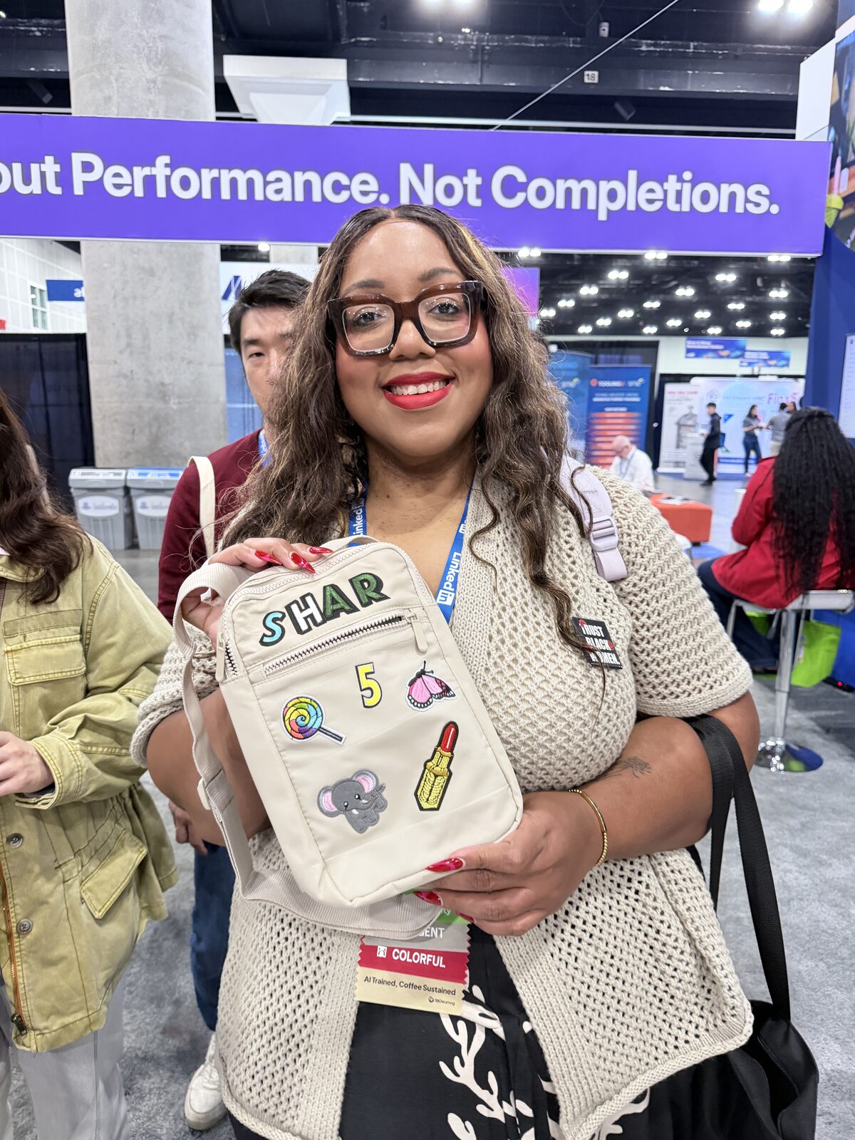 Smiling event guest holding a canvas tote she personalized at the patch bar